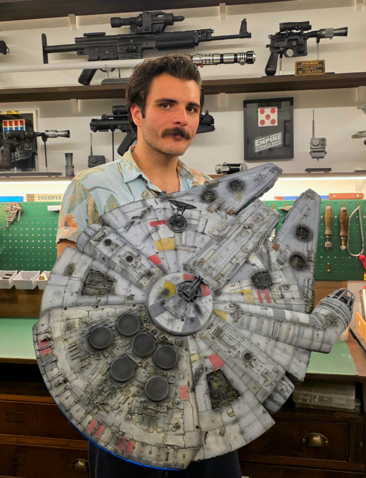 Tim mit einem detaillierten Millennium-Falcon-Modell in der Werkstatt